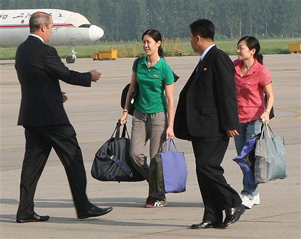 Journalists Laura Ling (in green shirt) and Euna Lee (in pink shirt) head to the plane after four months in North Korea prisons
